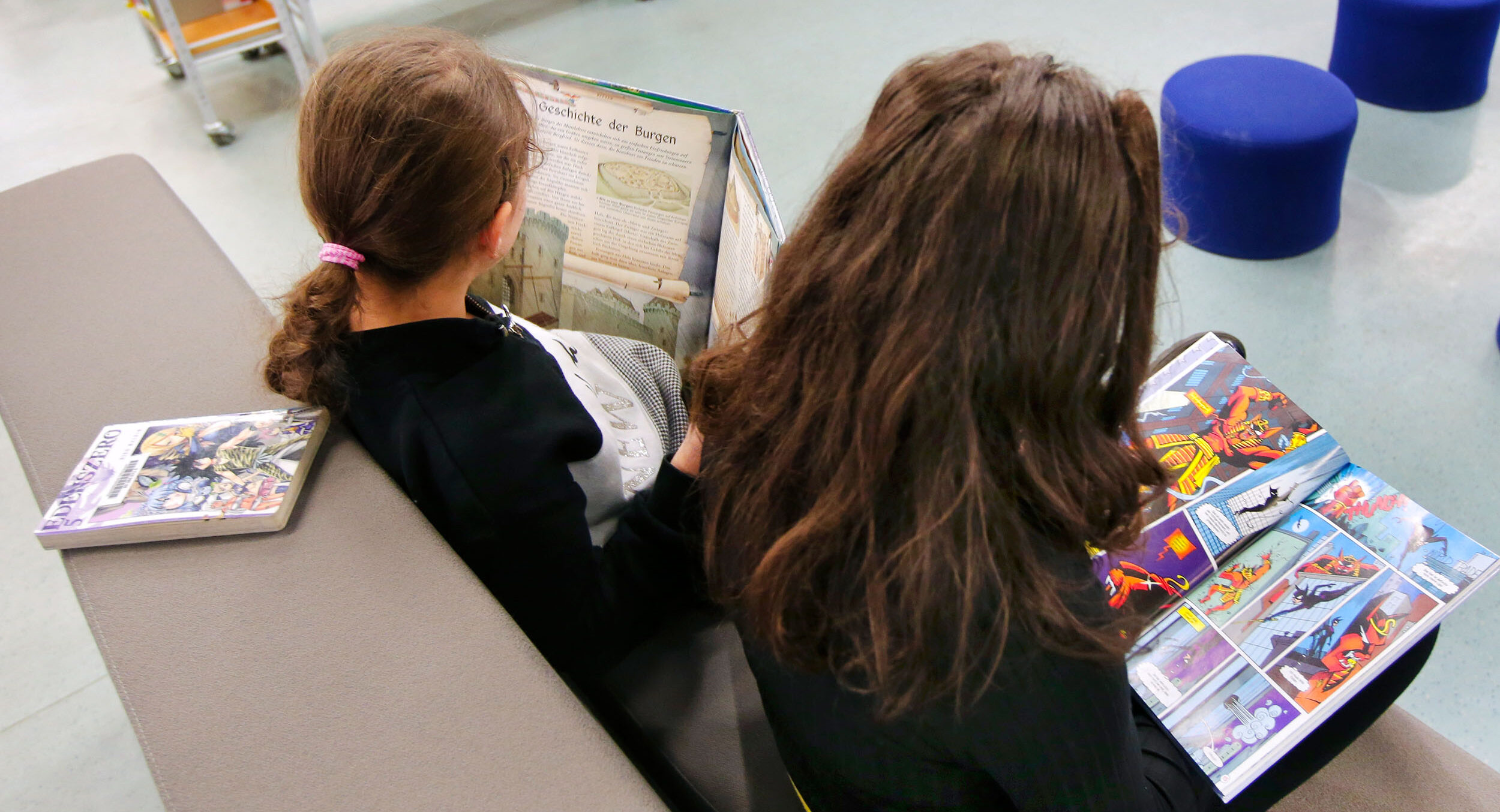 Kinder schauen sich Bücher in der Kinderbibliothek an.