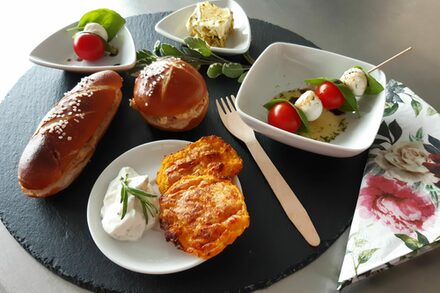 Teller mit Laugengebäck, Tomate-Mozzarella-Spieß und Frischkäse
