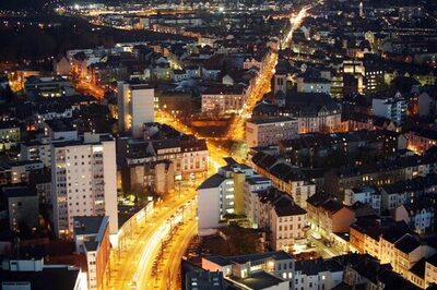 Straßen in der nächtlichen Innenstadt von Offenbach sind durch den Autoverkehr beleuchtet.