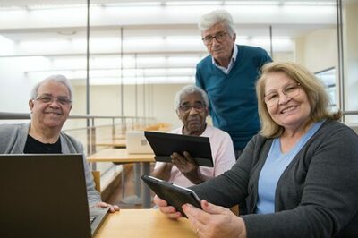 Senioren mit Tablets und Laptop