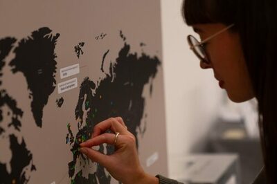 Eine Besucherin steckt Nadeln auf der World Map