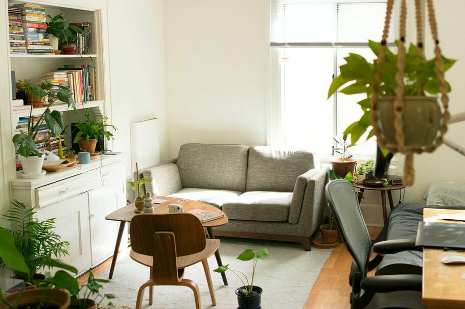 Blick in ein Wohnzimmer mit Couch, Bücherregal und Schreibtisch.