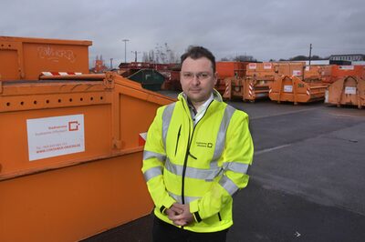 Der neue Geschäftsführer, Giuseppe Sessa, vor den orangenen Container des Stadtservice.