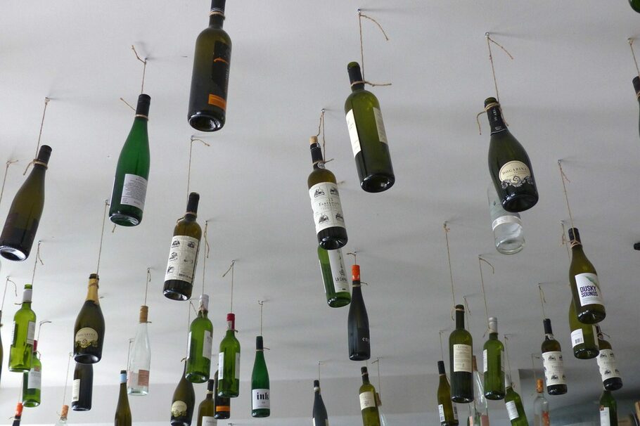Weinflaschen hängen als Deko von der Decke